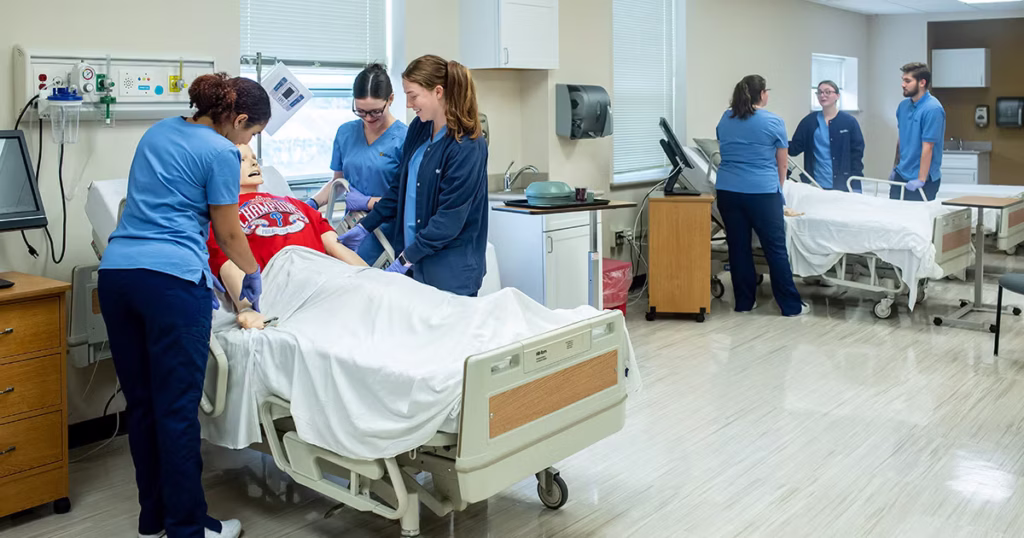 Bedside nursing students helping mannequin “patients” in the nursing simulation lab.